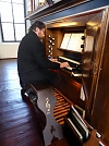 Pfarrer Werner Heizmann an der lausekalten Orgel (Foto: R. Englert)